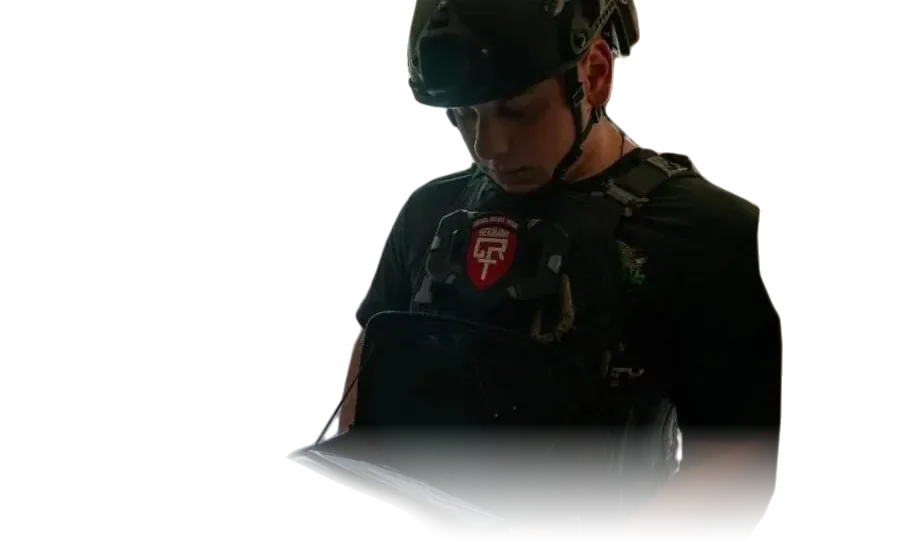 Einsatzkraft des Crisis Relief Team Germany mit Helm, Plattenträger und CRT-Abzeichen liest ein Tablet.