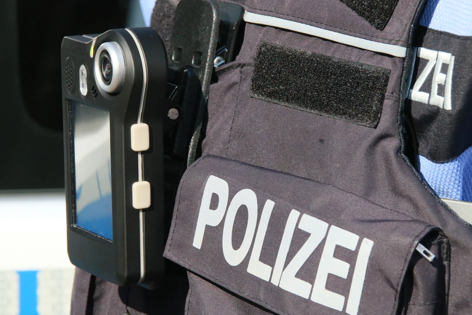 Cámara corporal en el chaleco de un policía con la inscripción Polizei.